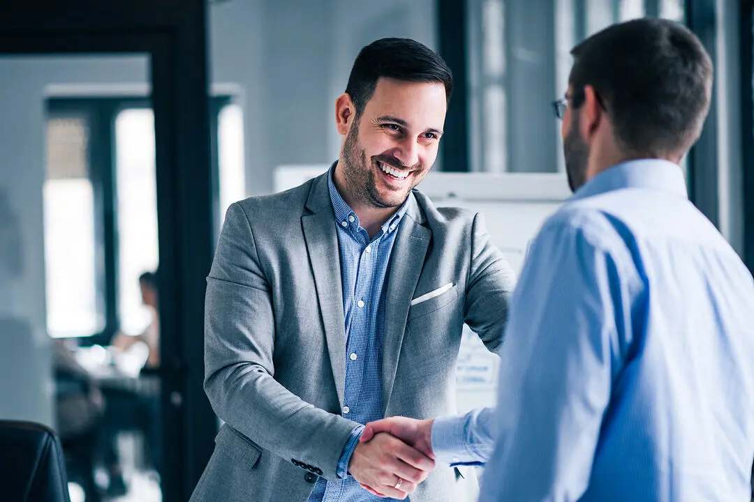 Two men in business attire shaking hands