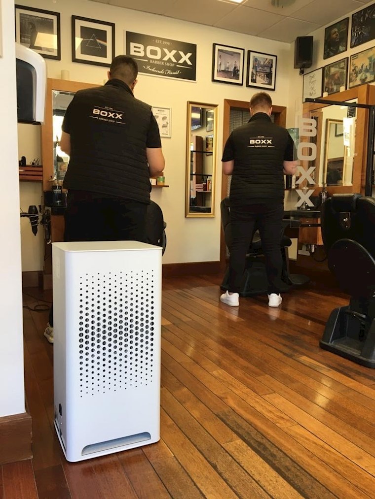 City M Luftreiniger in einem BOXX Barber Shop während zwei Friseure Ihren Kunden die Haare schneiden