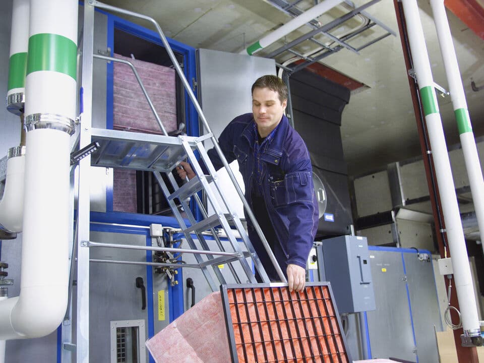 A man replacing an HVAC filter.