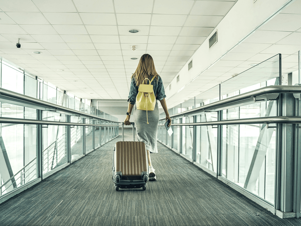 Frau mit Koffer und gelben Rucksack