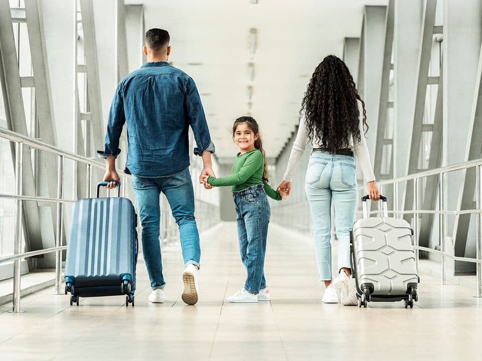 family in airport hallway with small child