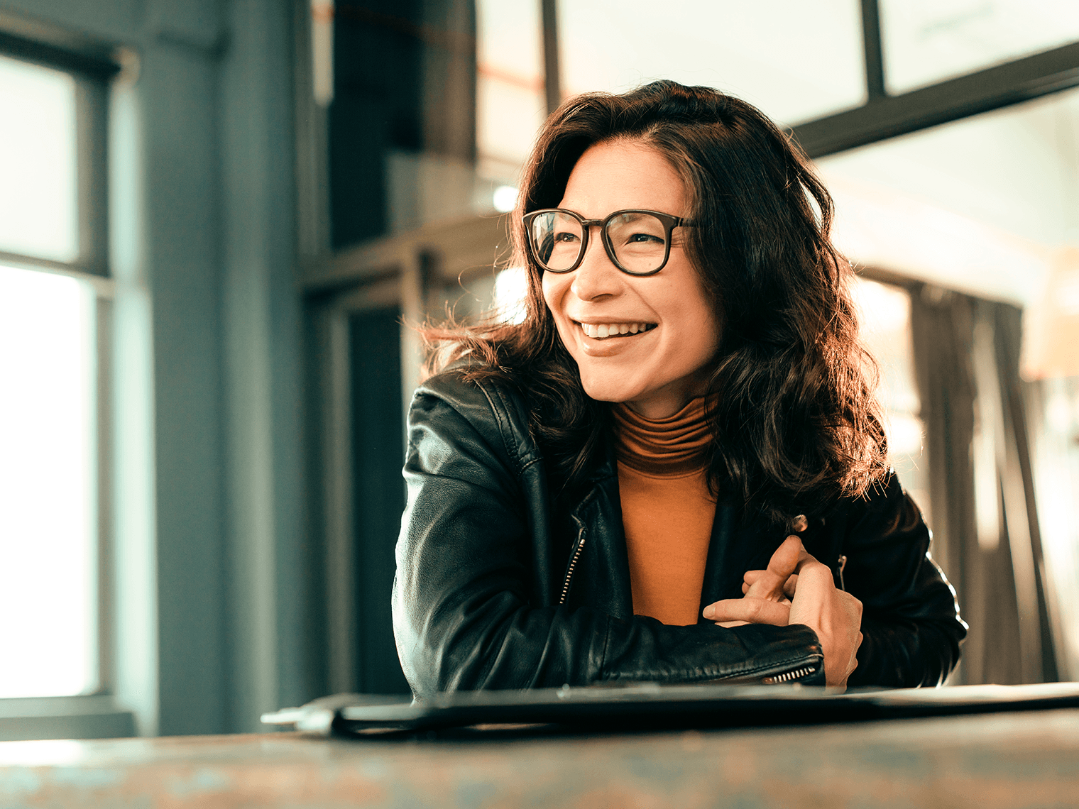 Young woman with glasses, indoors smiling
