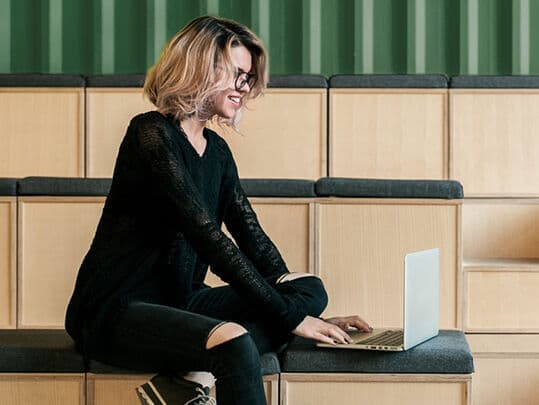 Woman reading news on a laptop