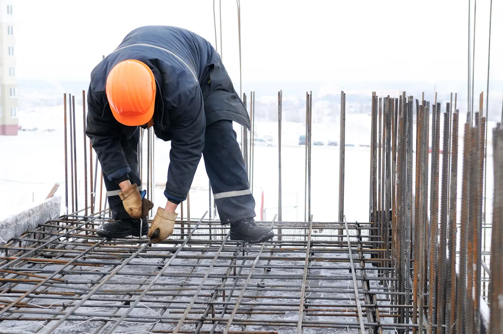 worker in workwear making reinforcement metal framework for concrete pouring