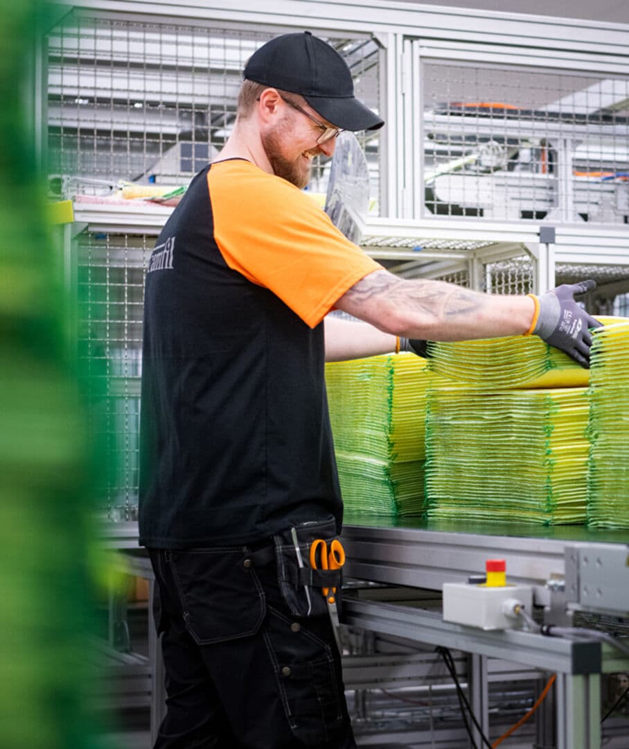 Mann in der Produktion von Camfil stapelt Filtertaschen