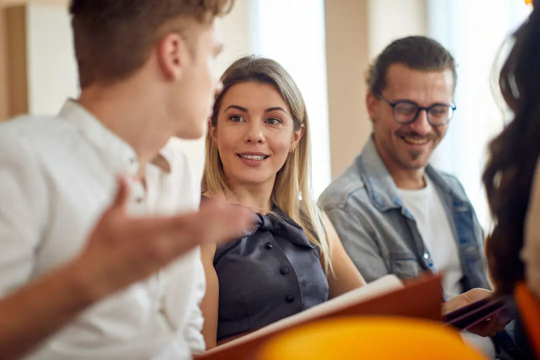 People sitting in a meeting, engaged in conversation with each other