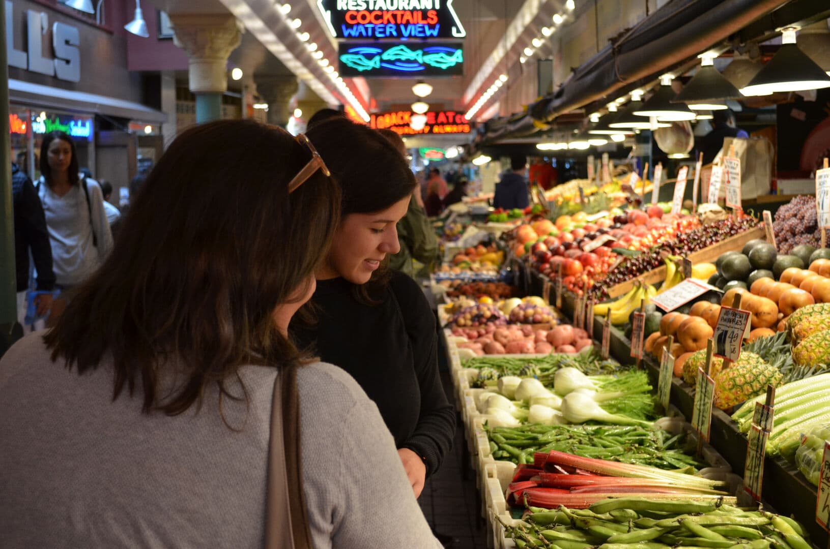 Grosery store with two women standing in front of the vegetables