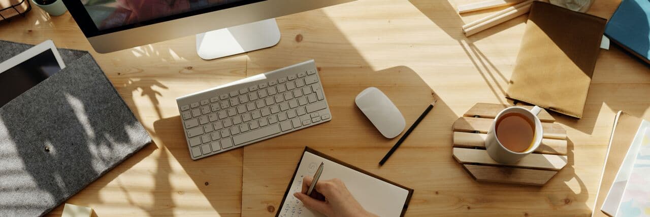Top-down view of a person attending a training session and taking notes.