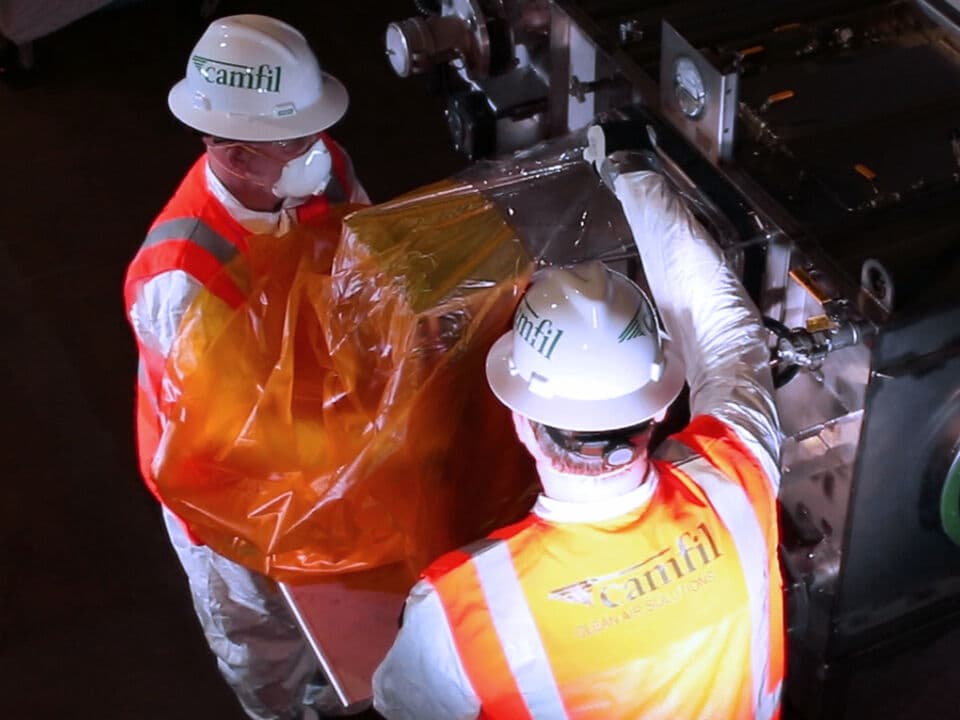 Two men replacing a HEPA filter.