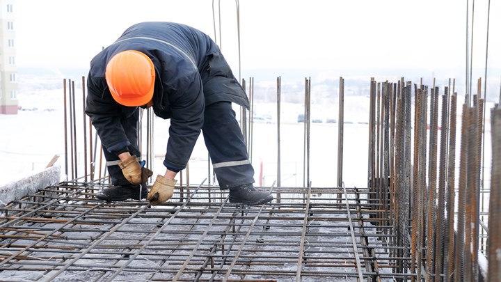 worker in workwear making reinforcement metal framework for concrete pouring