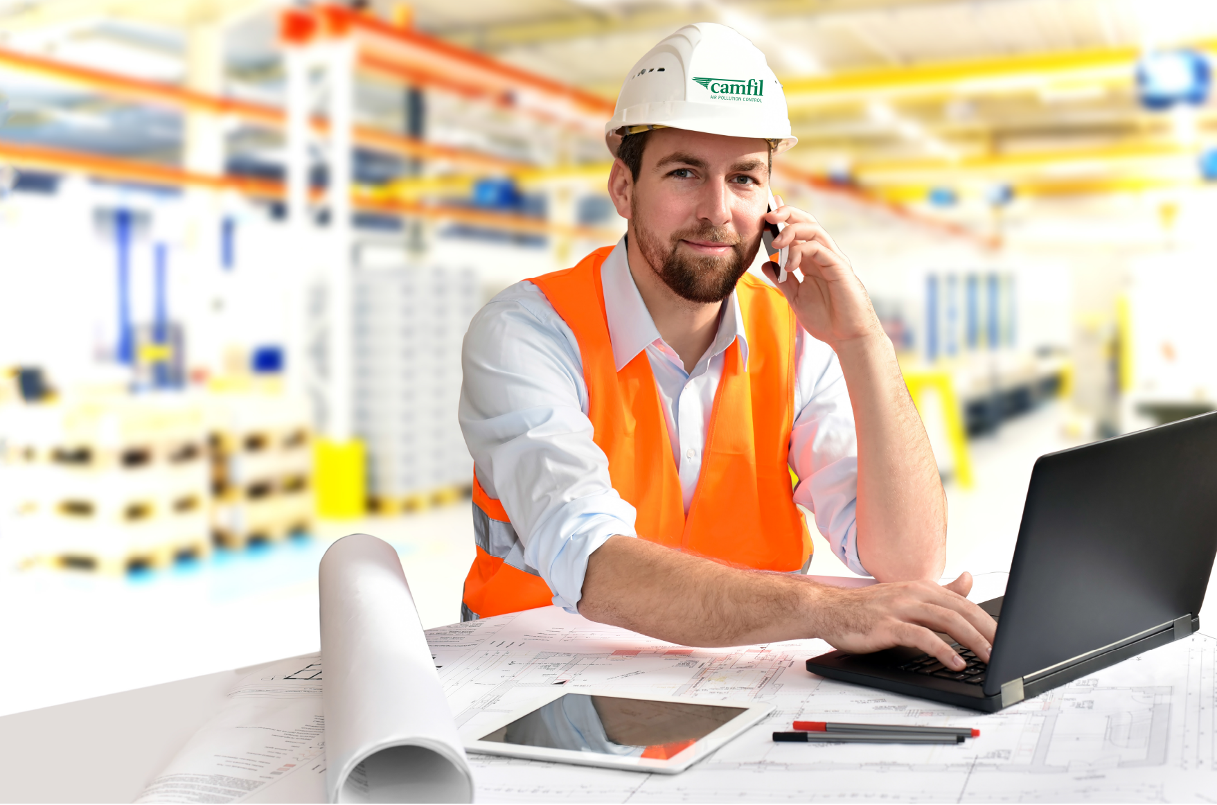 Service Mitarbeiter von Camfil mit Warnweste in einer Produktion telefoniert