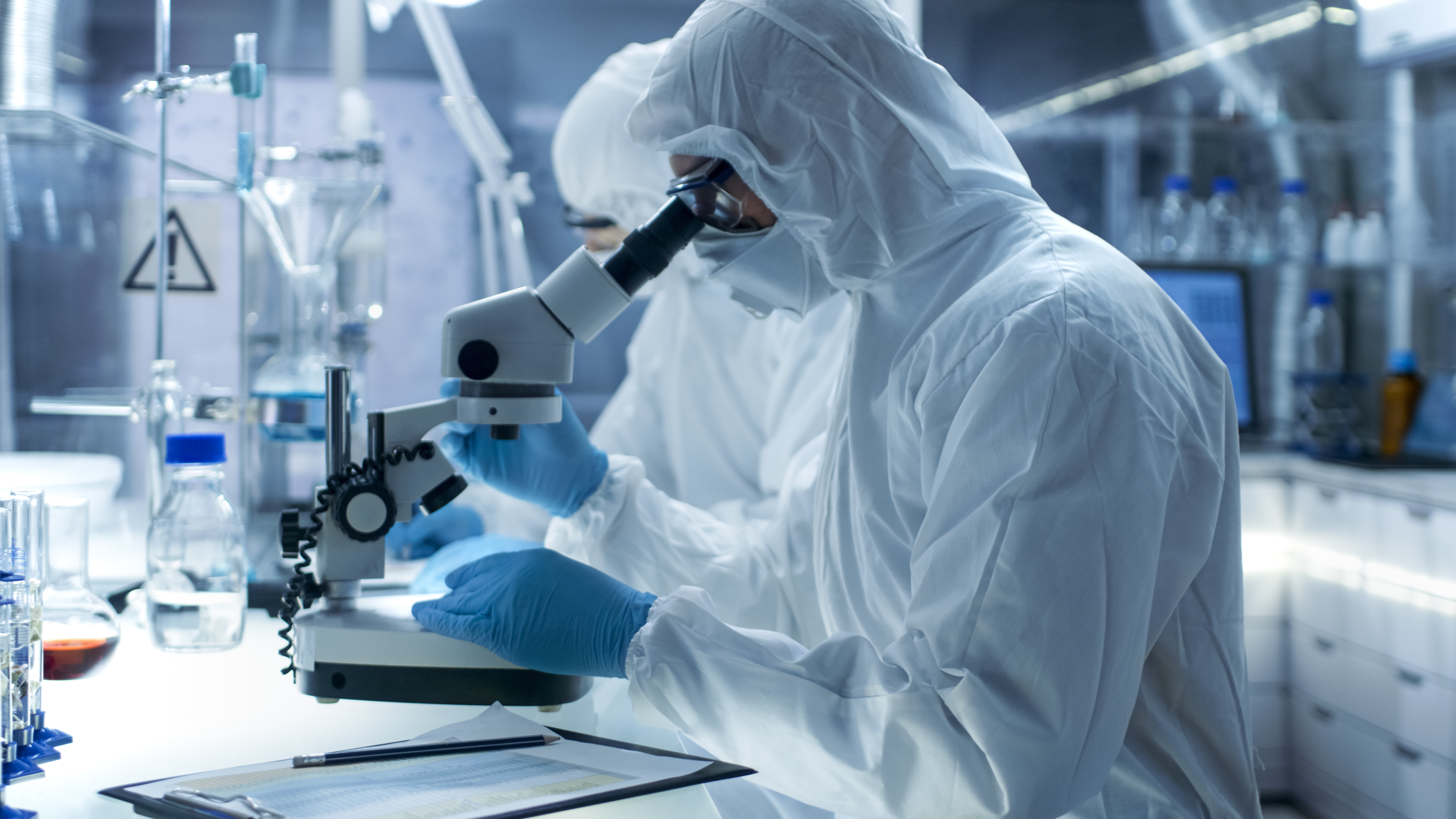 Secure high level laboratory scientists. Research scientists examine samples under microscope.